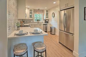 a kitchen with a large island with stools and a refrigerator at Orlando Vacation Rental Less Than 2 Mi to Lake Ivanhoe! in Orlando