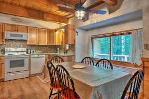 une cuisine avec une table et des chaises ainsi qu'un ventilateur de plafond dans l'établissement Cozy New Hampshire Retreat Near Skiing and Fishing!, à Bartlett