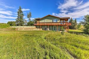 a house on a hill with a grass field at Rapid City Vacation Home with Wraparound Deck! in Rapid City