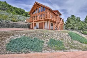 a log home on a hill with a house at Spacious Hilltop Cabin with Deck and Scenic Views! in Eden