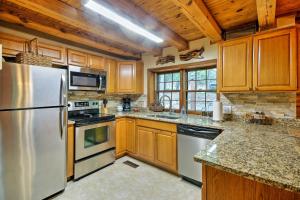 a kitchen with stainless steel appliances and wooden cabinets at Family-Friendly Massanutten Log Home with Views! in McGaheysville