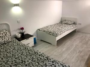 dwa łóżka w małym pokoju z dwoma łóżkami w obiekcie Cozy Apartment Malasaña FREE Parking w Madrycie
