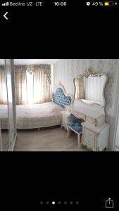 a bedroom with a bed and a desk and a chair at Квартира в центре города in Tashkent