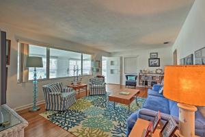 a living room with a blue couch and chairs at Chic Ormond Beach Cottage with Patio - Walk to Ocean in Ormond Beach