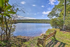 a bench sitting on the grass near a lake at 1 Mi to Big Boulder Lakefront Unit with Pool Access in Lake Harmony