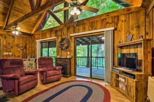 a living room with two chairs and a tv and a ceiling at Tellico Plains Cabin - 25 Acres, Backyard Creek! in Tellico Plains