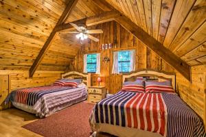 a bedroom with two beds in a log cabin at Tellico Plains Cabin - 25 Acres, Backyard Creek! in Tellico Plains