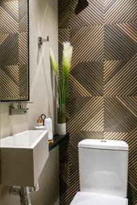 Un baño con un inodoro blanco y un lavabo. en Edificio Lindo Mar, en Itapema