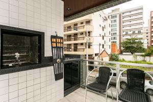 Un balcón con dos sillas y una chimenea. en Edificio Lindo Mar, en Itapema