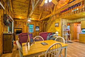 a dining room and living room in a wooden cabin at Tellico Plains Cabin - 25 Acres, Backyard Creek! in Tellico Plains