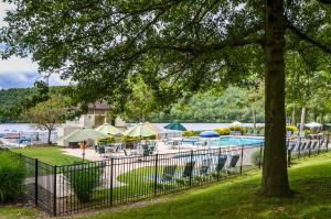 a pool with chairs and tables and umbrellas at 1 Mi to Big Boulder Lakefront Unit with Pool Access in Lake Harmony