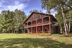 a large wooden house in the middle of a field at Restored Historic Lakefront Home with Panoramic Views in Lake Clear