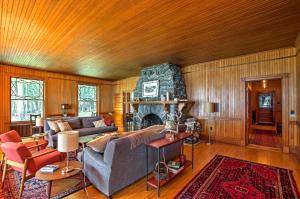 a living room with a couch and a fireplace at Restored Historic Lakefront Home with Panoramic Views in Lake Clear