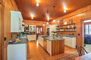 a large kitchen with wooden walls and wooden floors at Restored Historic Lakefront Home with Panoramic Views in Lake Clear