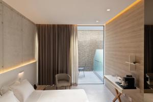 a hotel room with a bed and a desk and a chair at Posia Retreat & Spa UNA Esperienze in San Foca