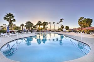 a large swimming pool with chairs and palm trees at Spacious Golf Home with Yard at Indian Palms Resort! in Indio