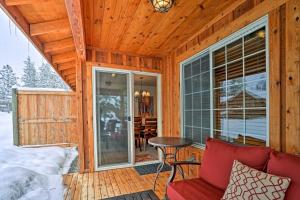 a cabin with a red couch and a table on a porch at Spacious Winthrop Home-Walk to Trails, Restaurants in Winthrop