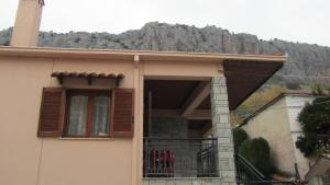 une maison avec un balcon donnant sur la montagne en arrière-plan dans l'établissement Archontiko Theopetra, à Theópetra