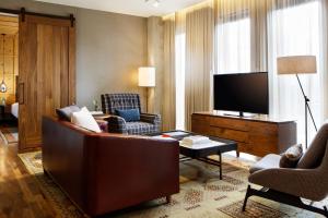 uma sala de estar com um sofá e uma televisão de ecrã plano em Limelight Hotel Denver em Denver