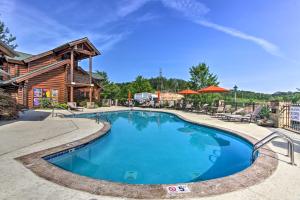 a swimming pool in front of a log cabin at Pigeon Forge Vacation Rental 1 Mi to Dollywood in Pigeon Forge