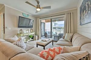 a living room with a couch and a tv at St Simons Island Condo with Pool Near Beach, Village in East End
