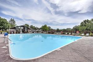 a large blue swimming pool with a building in the background at Holiday Hills Resort Condo 3 Mi to Branson Strip! in Branson