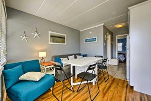 a living room with a table and a blue couch at North Wildwood Condo with Pool, Walk to Boardwalk! in North Wildwood