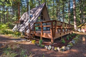 uma grande cabana de madeira no meio de uma floresta em Serene Washington Escape with Deck and Mountain Views! em Packwood