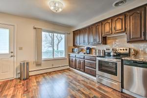 a kitchen with wooden cabinets and a large window at Waterfront Home with Shared Dock on Lake St Clair! in Chesterfield +16 photos