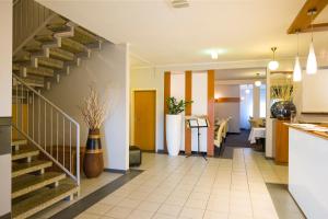 a hallway with a staircase and a dining room at Hotel Garden Cottage mit kostenfreien Parkplätzen in Dresden