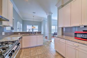 a large kitchen with white cabinets and a sink at Updated Home 15 Mins to the Galleria and Uptown! in Houston