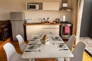 a kitchen with a white table with wine glasses on it at Lobos de Mar in Punta Del Diablo