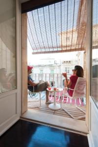 eine Gruppe von Menschen, die auf einem Balkon am Tisch sitzen in der Unterkunft Ortigia Suite - Archimede in Syrakus