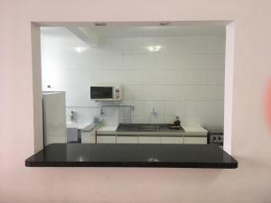 a kitchen with a refrigerator and a counter top at Apto 3a Avenida Balneário Camboriu in Balneário Camboriú