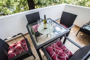 - une table avec 2 chaises et une bouteille de vin dans l'établissement Villa Elkom, App.9, à Ulcinj