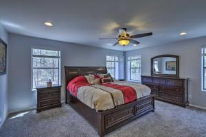 a bedroom with a bed and a ceiling fan at 3 Mi to Rainbow Lake Home with Hot Tub and Deck in Pinetop-Lakeside
