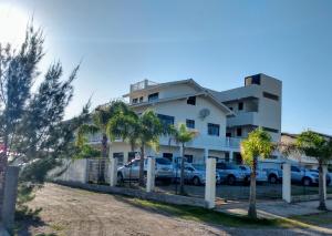 um edifício com carros estacionados em frente em Apartamento Ilha do Coral em Palhoça