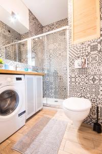 uma casa de banho com uma máquina de lavar roupa e um WC em UNO Apartaments em Katowice