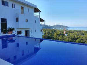 ein Blick vom Hotelpool mit Blick auf das Meer in der Unterkunft Sunset House Zihuatanejo in Zihuatanejo