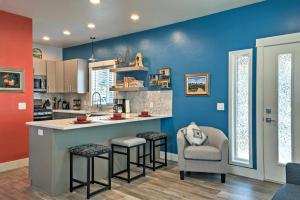 una cocina con paredes azules, encimera y taburetes en Missoula Getaway with Balcony, 2 Mi to Downtown!, en Missoula
