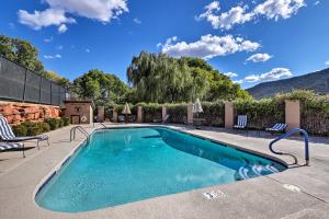 a swimming pool with chairs and a mountain in the background at Canyon Mesa Golf Condo with Majestic Mountain Views! in Sedona