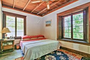 ein Schlafzimmer mit einem Bett in einem Zimmer mit Fenstern in der Unterkunft Island Cottage on Evans Lake - Bring Your Boat! in Tipton