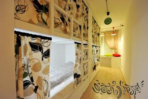 Habitación con pasillo, cama y cortinas. en Scotch Hostel, en Volgograd