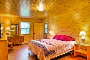 ein Schlafzimmer mit einem Bett in einer Holzhütte in der Unterkunft Peaceful Cabin Near Little River Canyon! in Fort Payne