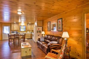a living room with a leather couch and a kitchen at Peaceful Cabin Near Little River Canyon! in Fort Payne