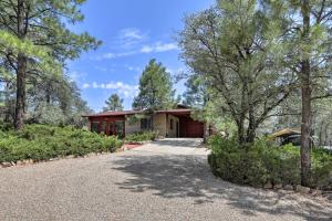 a home in the woods with a driveway at Quiet Prescott Forest Retreat Cottage with Patio! in Prescott