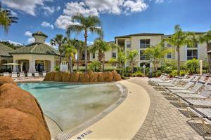 un complexe avec piscine et chaises longues dans l'établissement Resort-Style Condo with Pool 6 Mi to Magic Kingdom, à Kissimmee