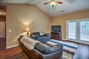 a living room with a leather couch and a flat screen tv at Branson Home with Deck Walk to The Strip and Creek! in Branson