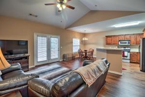 a living room with leather furniture and a kitchen at Branson Home with Deck Walk to The Strip and Creek! in Branson