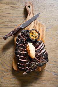 a cutting board with a piece of meat and a knife at Kimpton Hotel Vintage Portland, an IHG Hotel in Portland